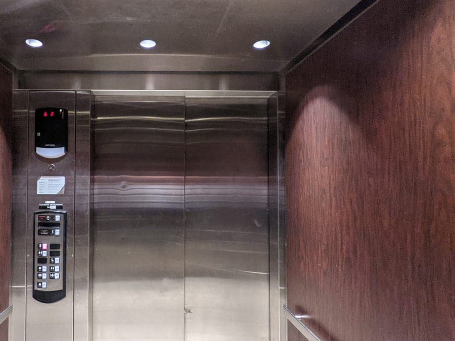 Interior de un ascensor con puertas metálicas