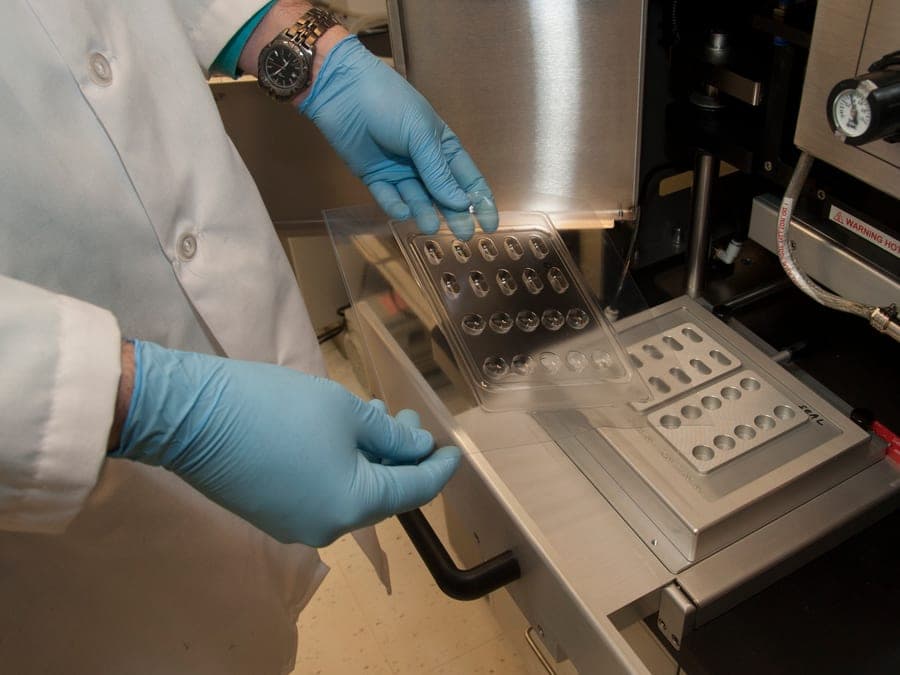 Operario manipulando blísteres en una línea de producción farmacéutica